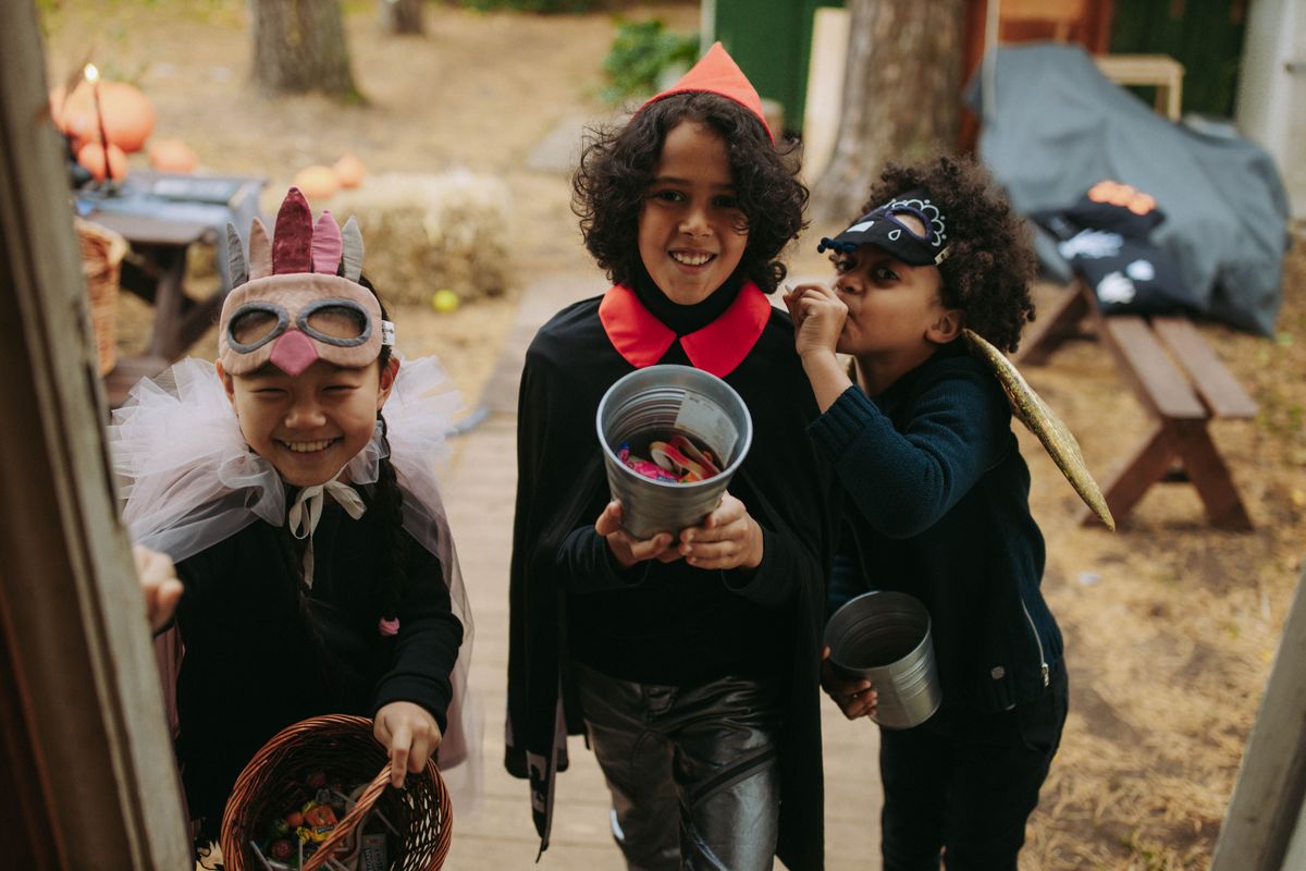 Kids in fun Halloween costumes with candy buckets